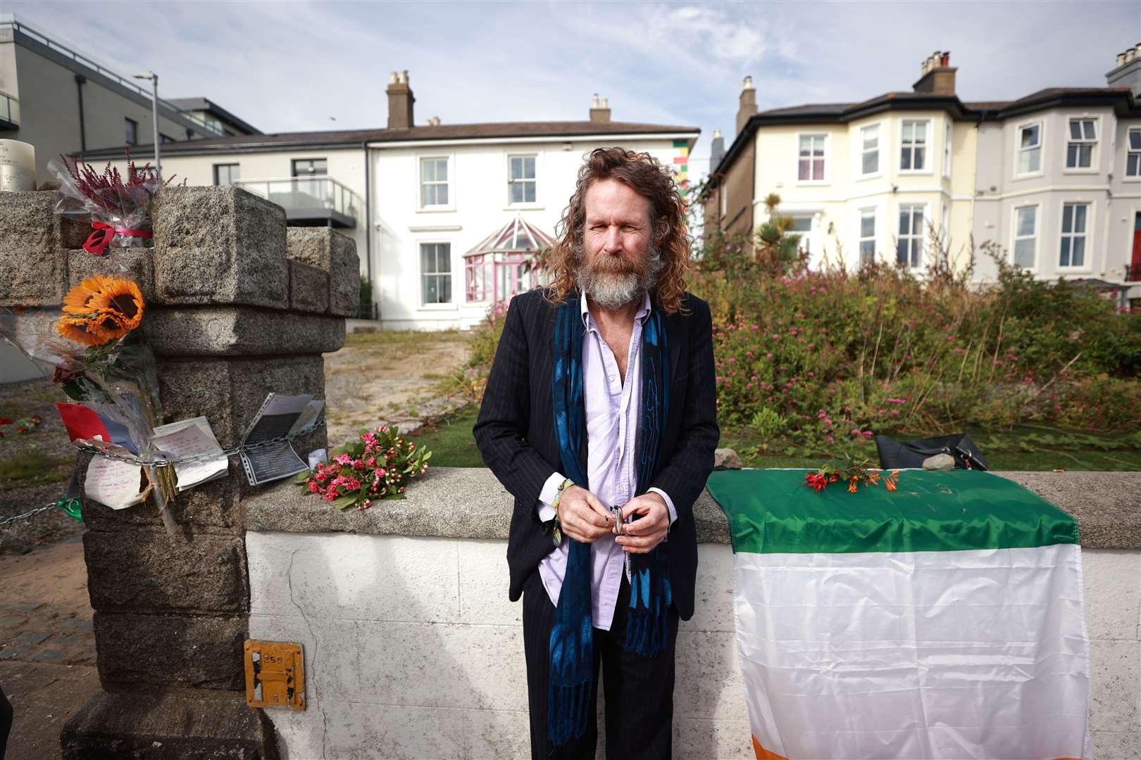 Liam O Maonlai, lead singer of Hothouse Flowers, pays tribute to the singer outside her former home (Liam McBurney/PA)