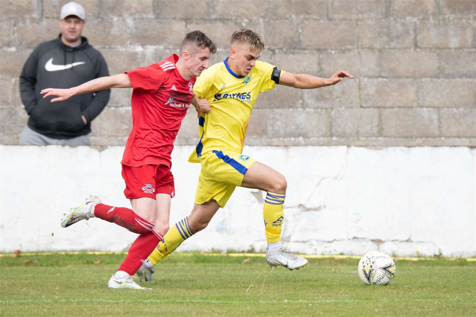Lossiemouth's Ross Morrison and Buckie's Mark Mclauchlan tussle for the ball. Picture: Daniel Forsyth..