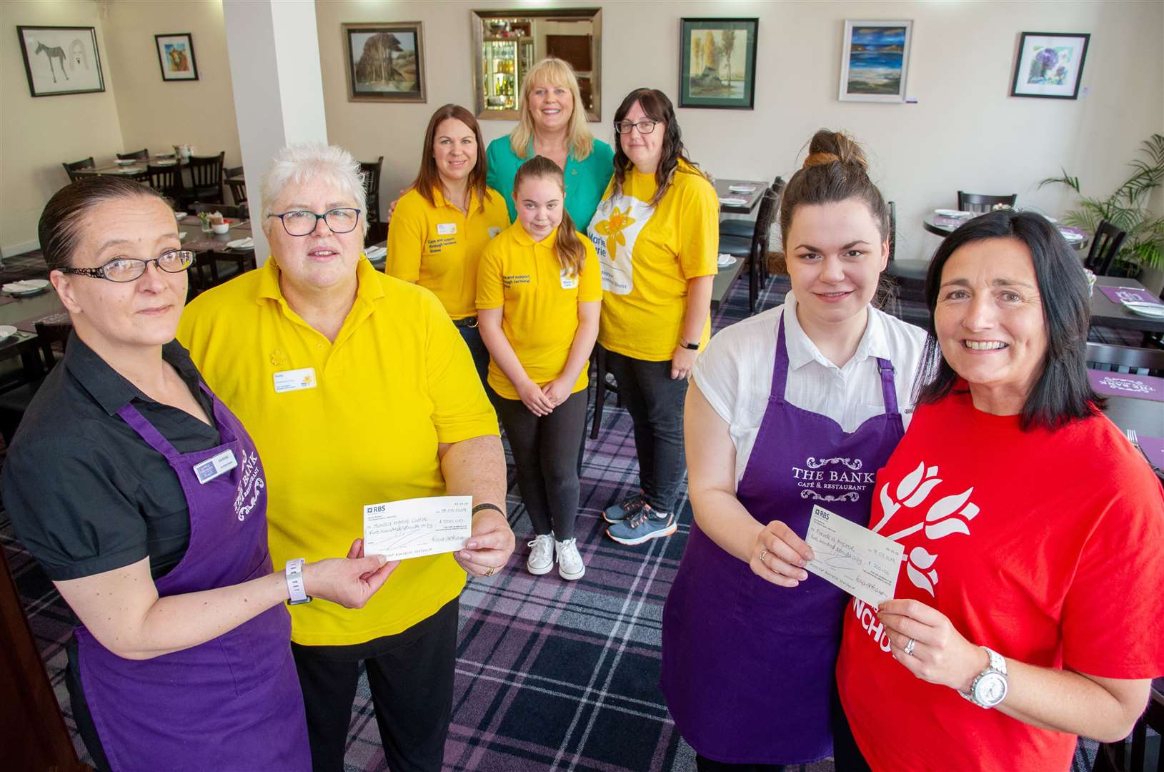 The Bank Cafe hands over a pair of cheques for £500 to Marie Curie and The Friends of Anchor which they raised from various raffles and by donating a share of their tips. Left to Right: Denise Robertson (supervisor at The Bank), Alison Nicoll (chairperson of the Huntly Marie Curie Group), Debbie Morrison, Katie Morrison, Fiona Pearson (Owner at The Bank), Kelly Coutts, Bethany Skinner (waitress at The Bank), Donna Miller (volunteer at the Friends of ANCHOR). Picture: Daniel Forsyth. Image No.044472.