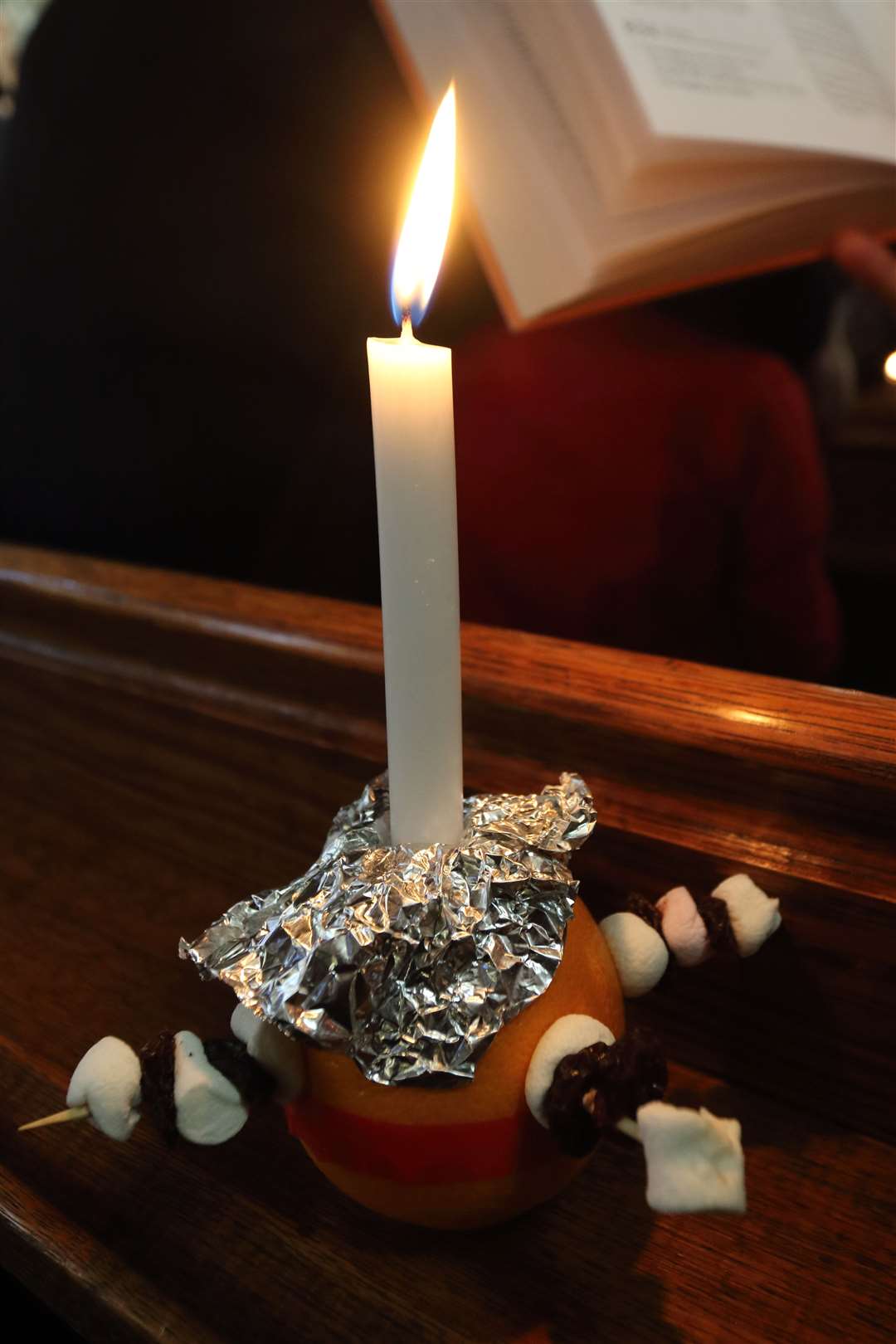 The congregation are provided with the Christingles which light up the church.