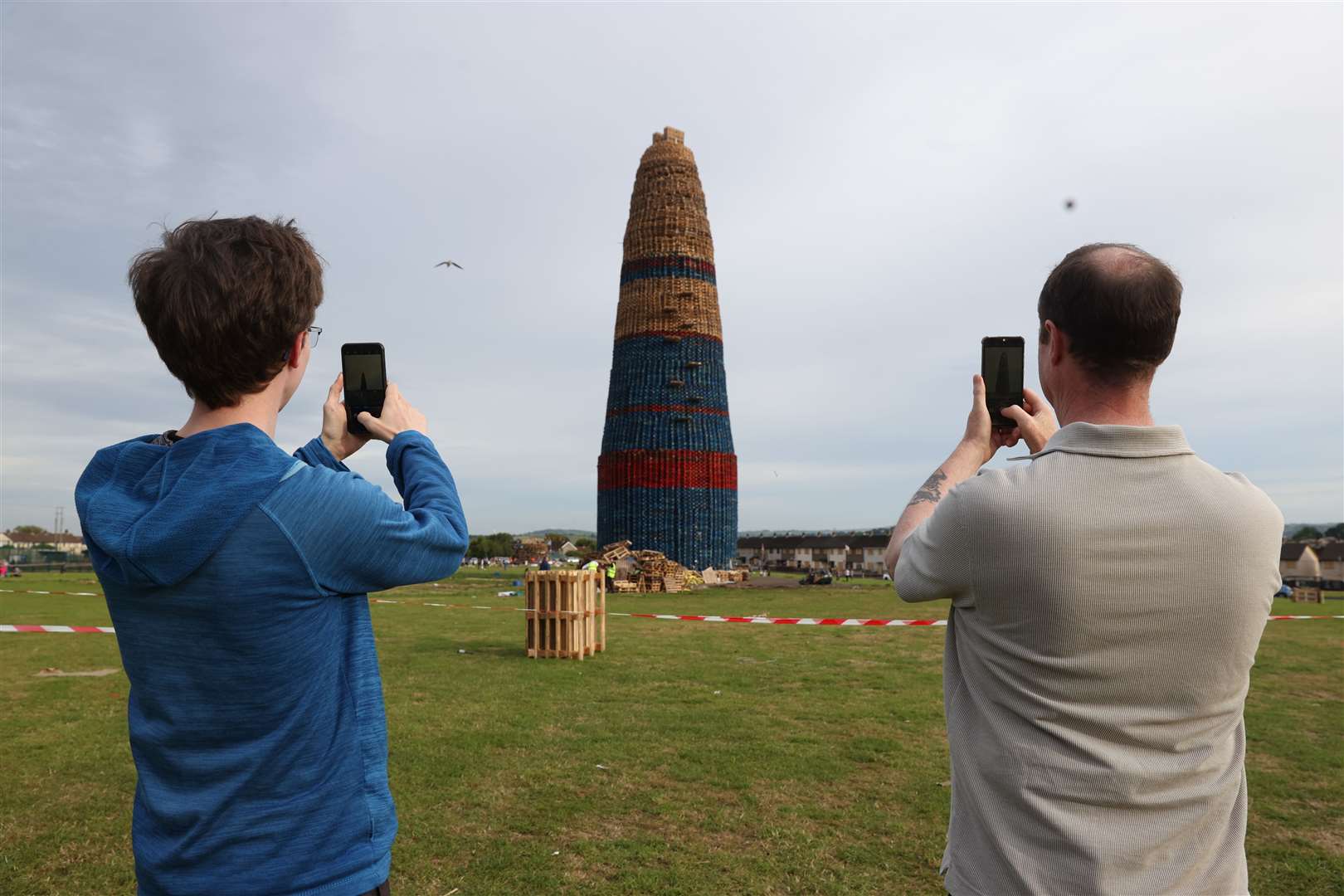 People take pictures of the Craigyhill bonfire in Larne, prior to it being lit on the ‘Eleventh night’ to usher in the Twelfth commemorations (Liam McBurney/PA)