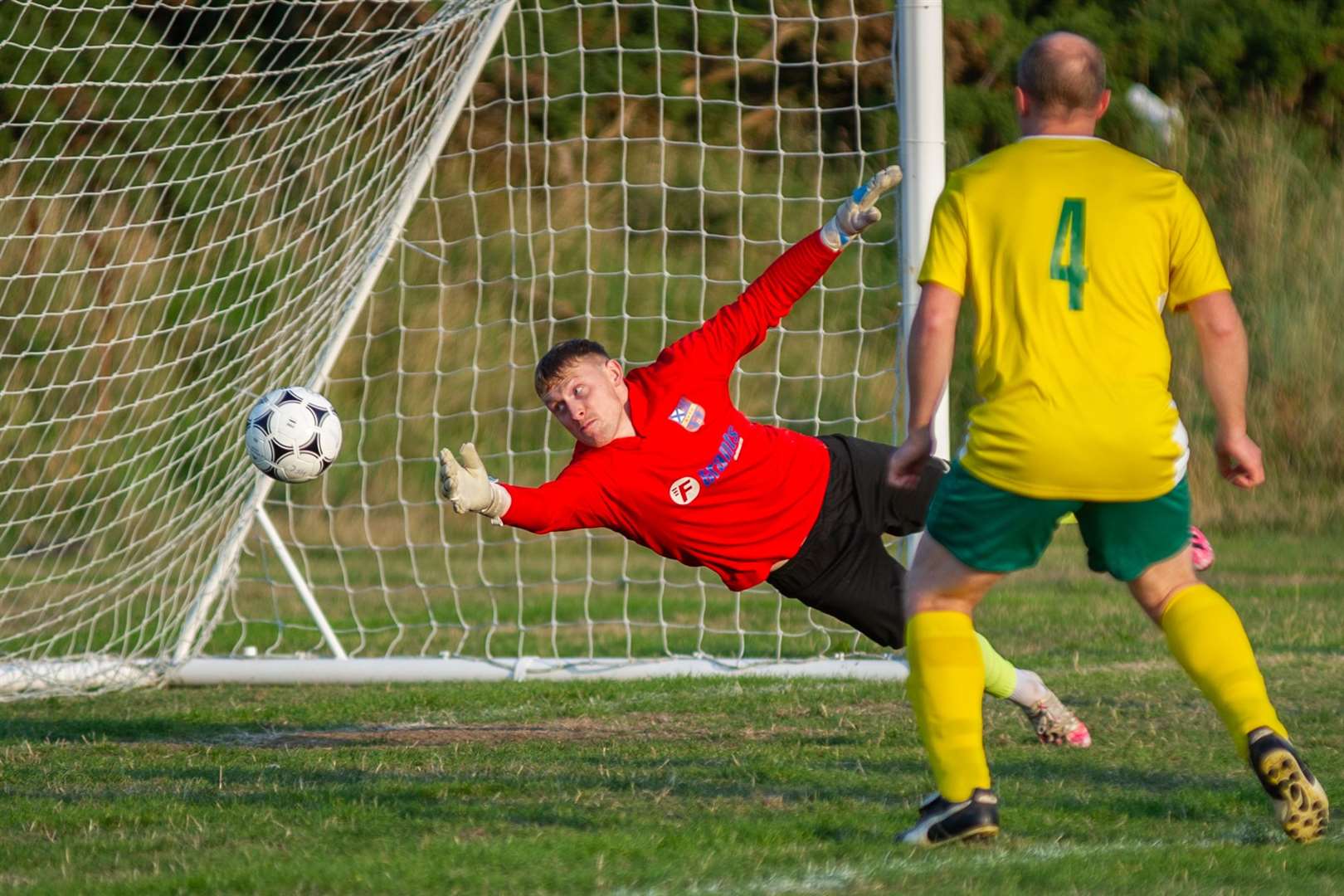 Aberlour keeper Paul Robertson is unable to keep out Hopeman's opening goal from Graeme Ingram. Picture: Daniel Forsyth..