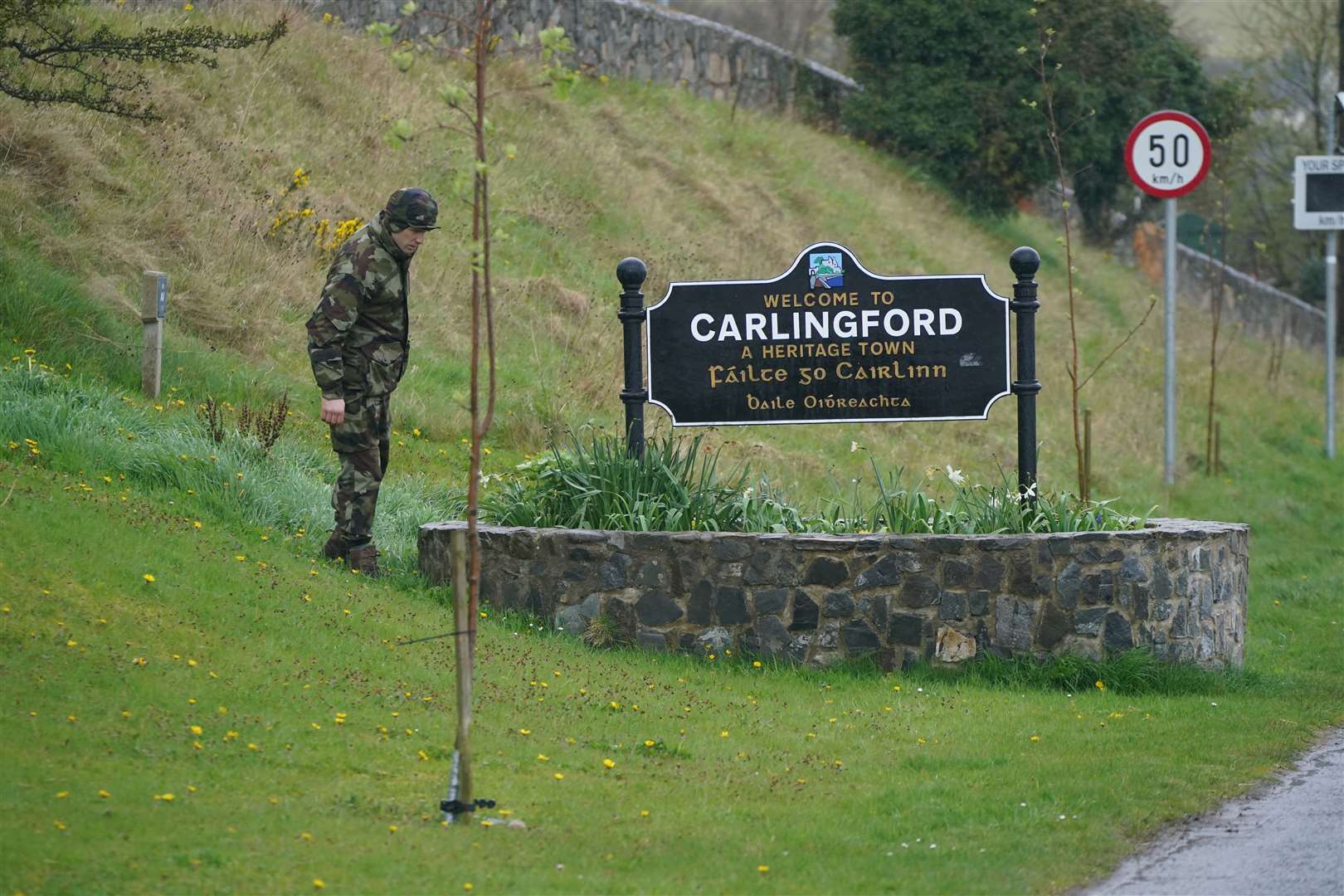 A member of the defence forces carries out searches at the entrance to Carlingford, Co Louth, ahead of a visit from US President Joe Biden (Niall Carson/PA)