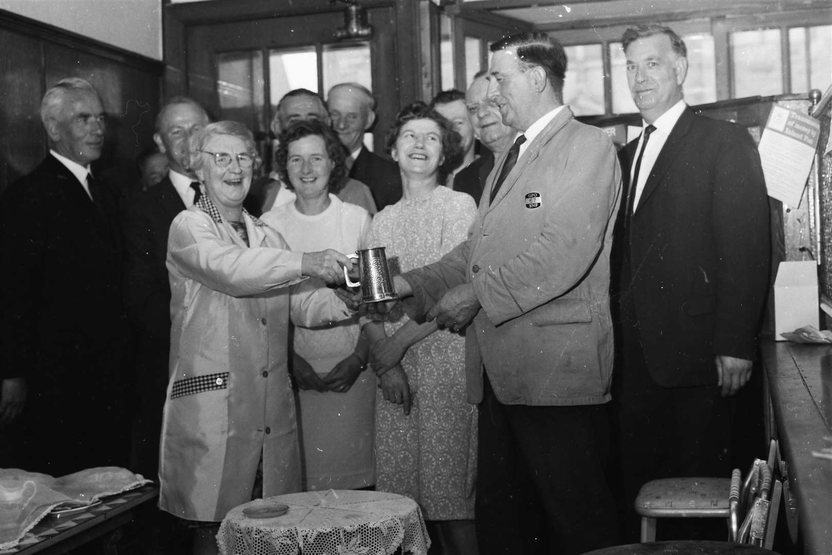 Bob Mcaulay receives a tankard from Cullen postmistress Jeannie Milne. Standing next to her is her eventual successor in the role, Kathleen Ross.