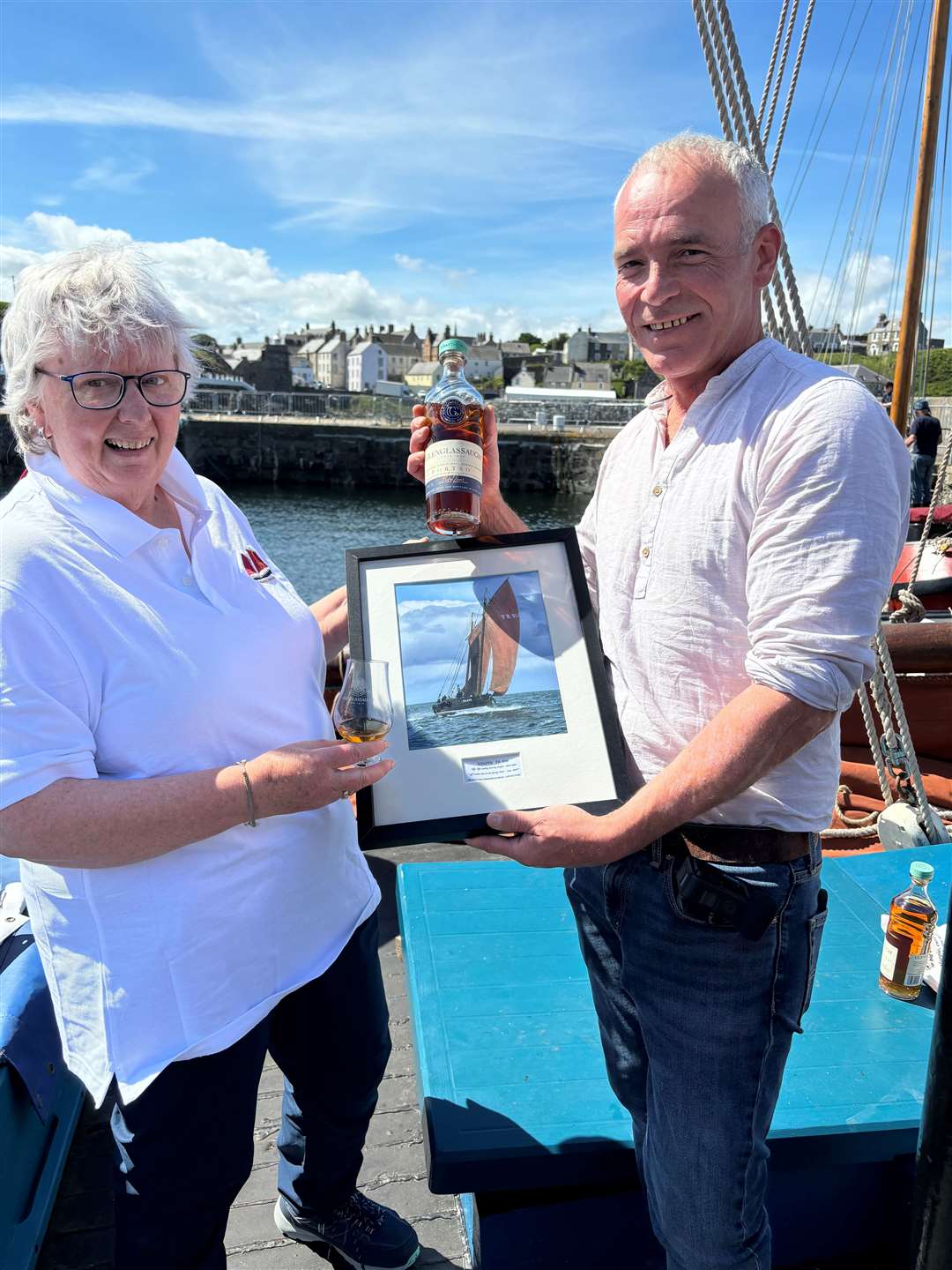 Joan Paton of the Scottish Fisheries Museum presents a framed picture of the Reaper to Stewart Buchanan, Glenglassaugh global brand ambassador.