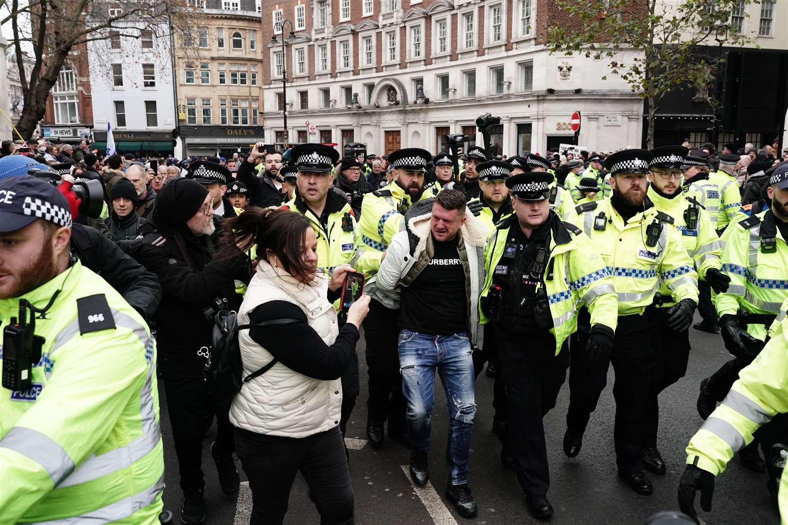 Tommy Robinson is led away by police officers as people take part in a march against antisemitism (Jordan Pettitt/PA)
