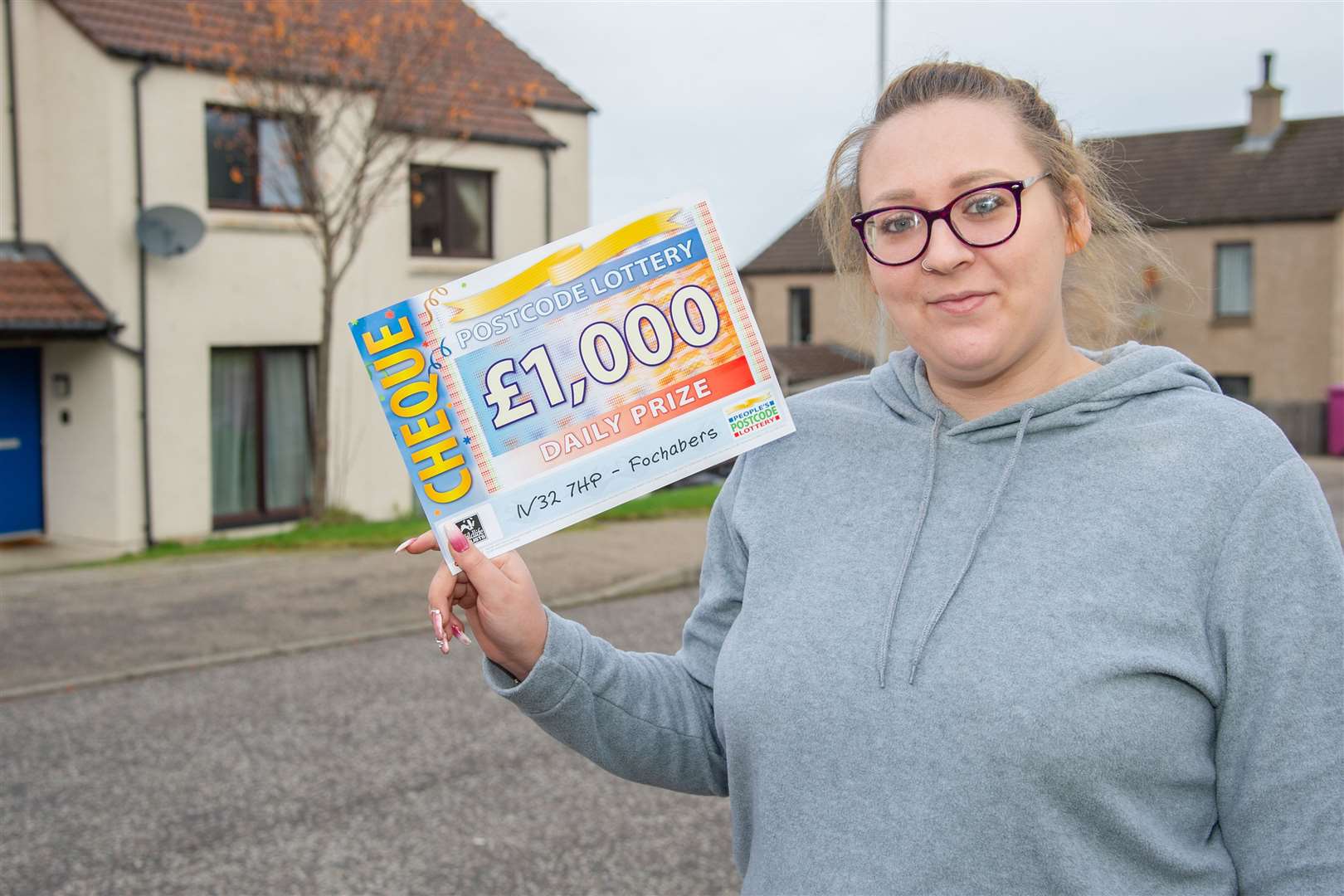 Feeling grand...Samantha Barnes with her share of the People's Postcode Lottery prize money. Picture: Daniel Forsyth