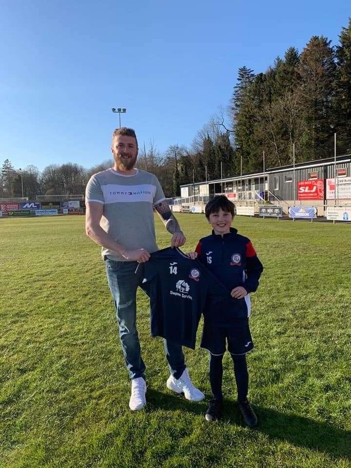 Shaun Jay of Simpson Services Turriff presents the new training kits to son Jack.