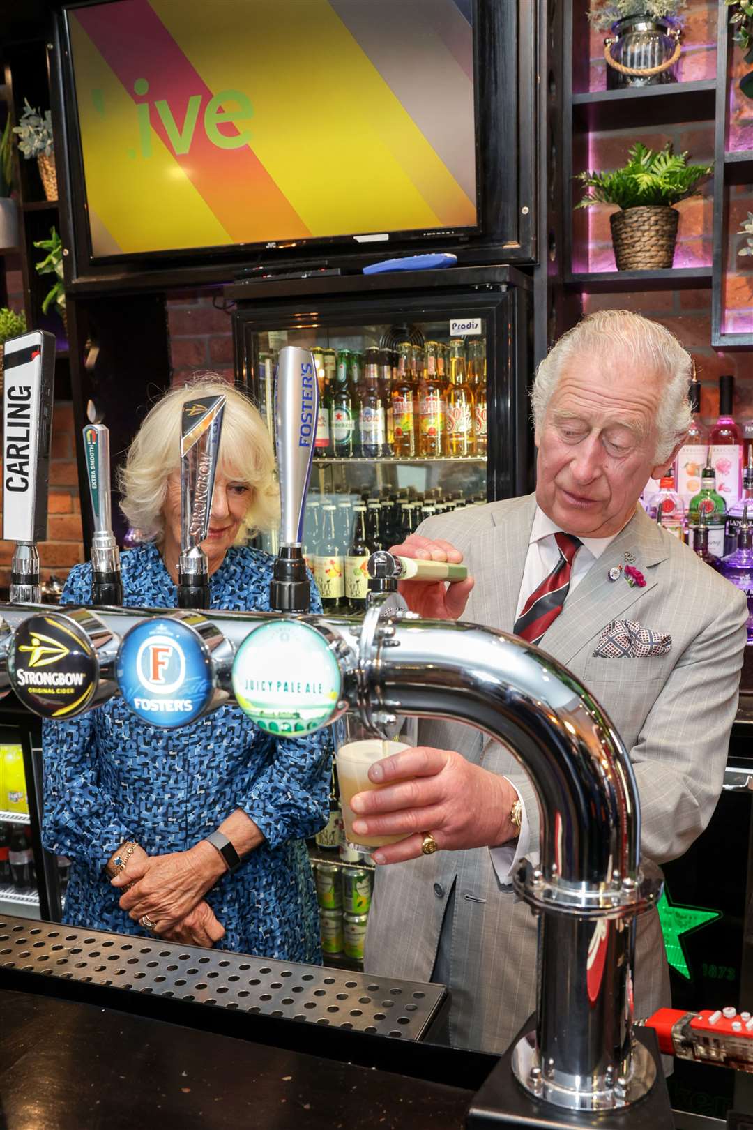 The Prince of Wales and the Duchess of Cornwall behind the bar at The Lion pub (Chris Jackson/PA)