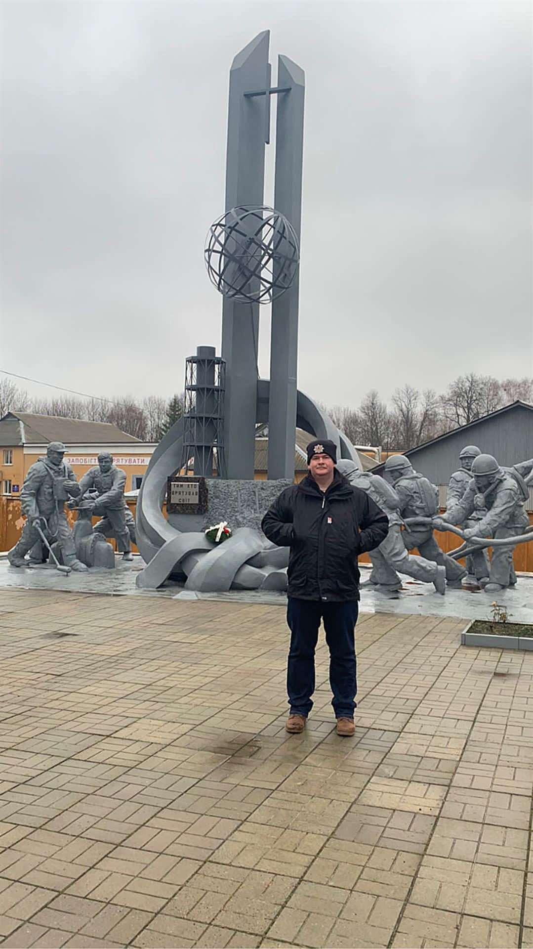 Mark Allan at "The men who saved the world statue" outside a fire station in Chernobyl.