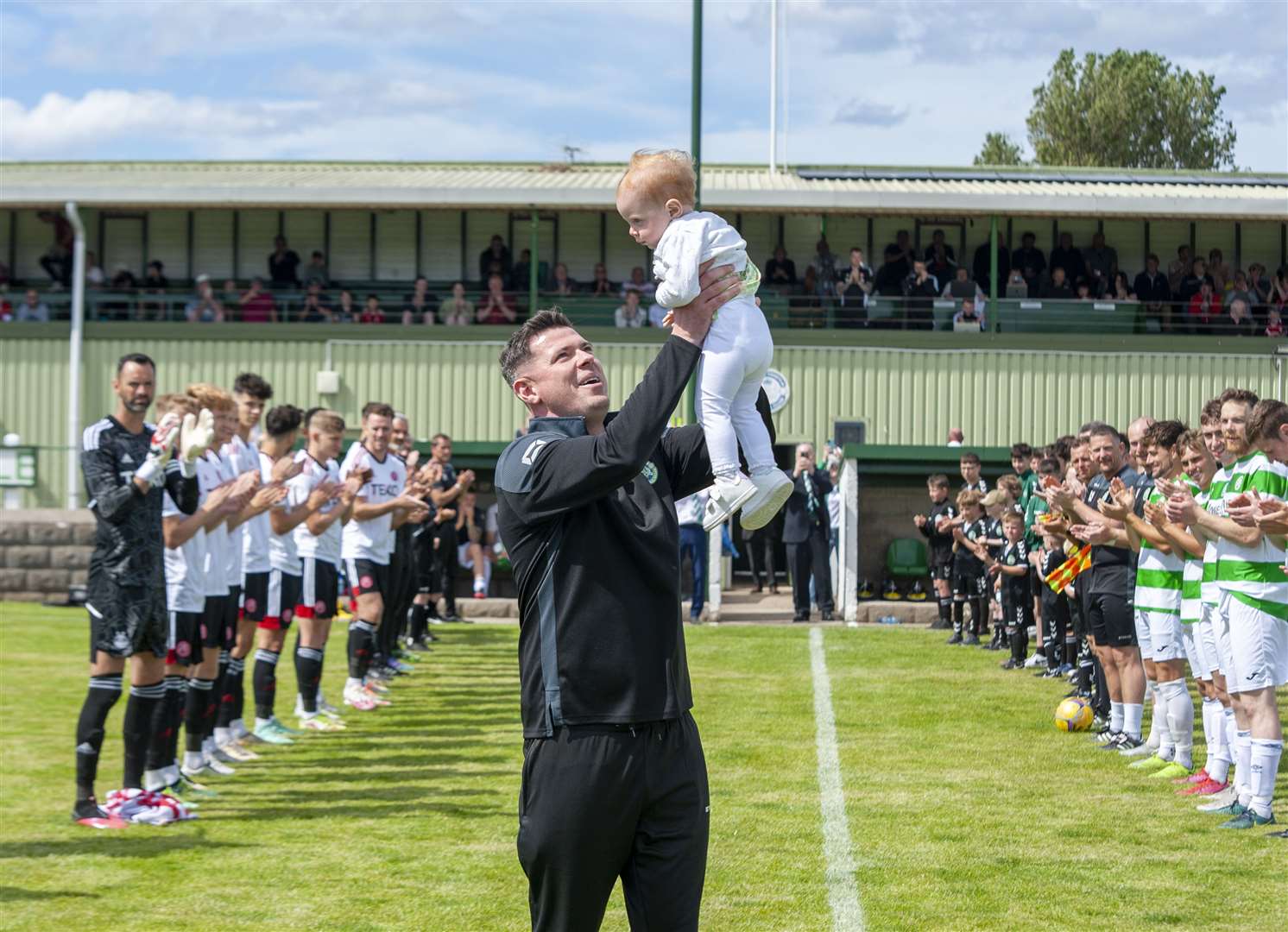 Graeme Stewart holds his young daughter Erin aloft after being given a guard of honour by the players before the game. Picture: Allan Robertson