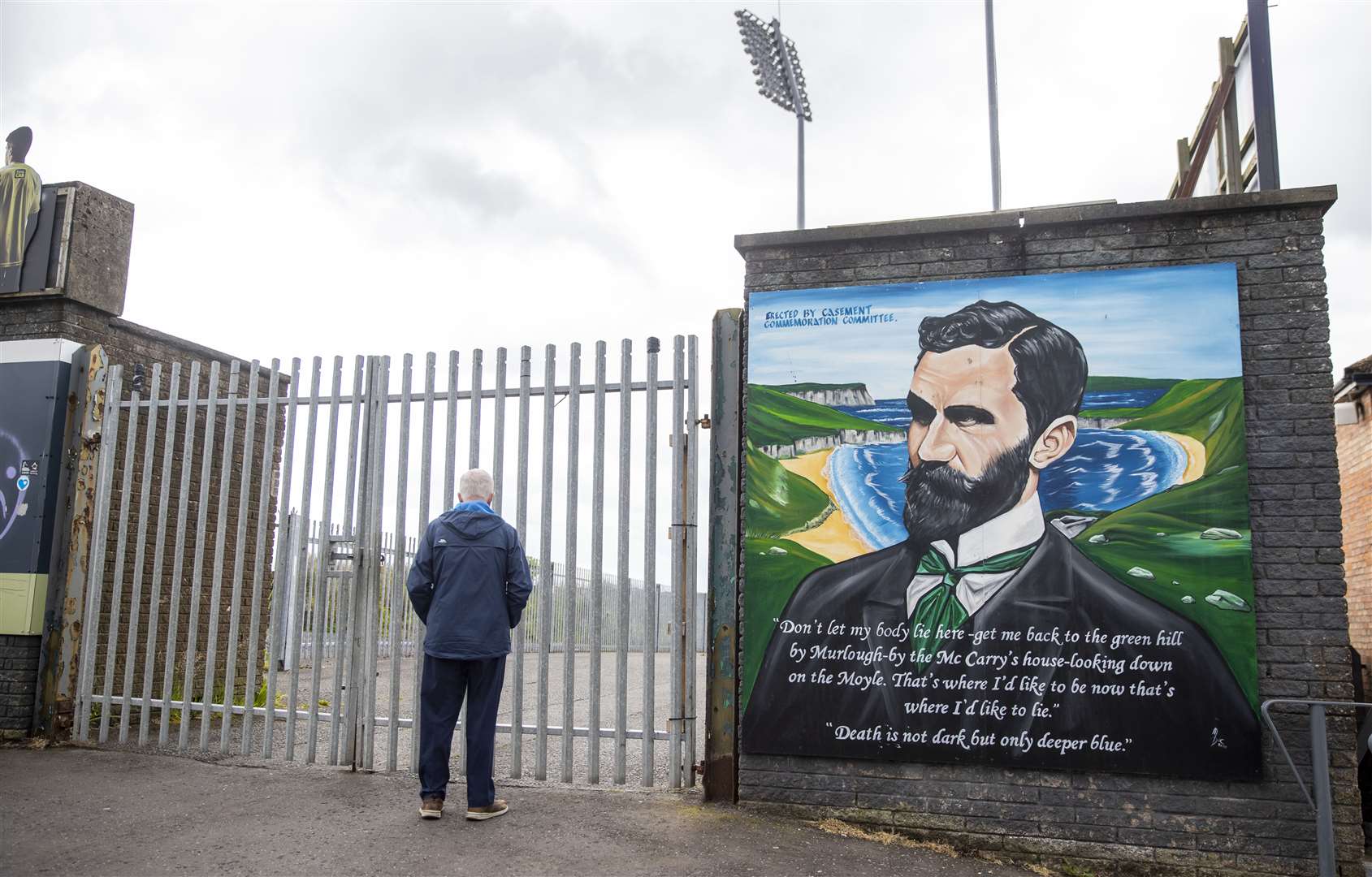 A man stands at the locked gates of Casement Park (Liam McBurney/PA)