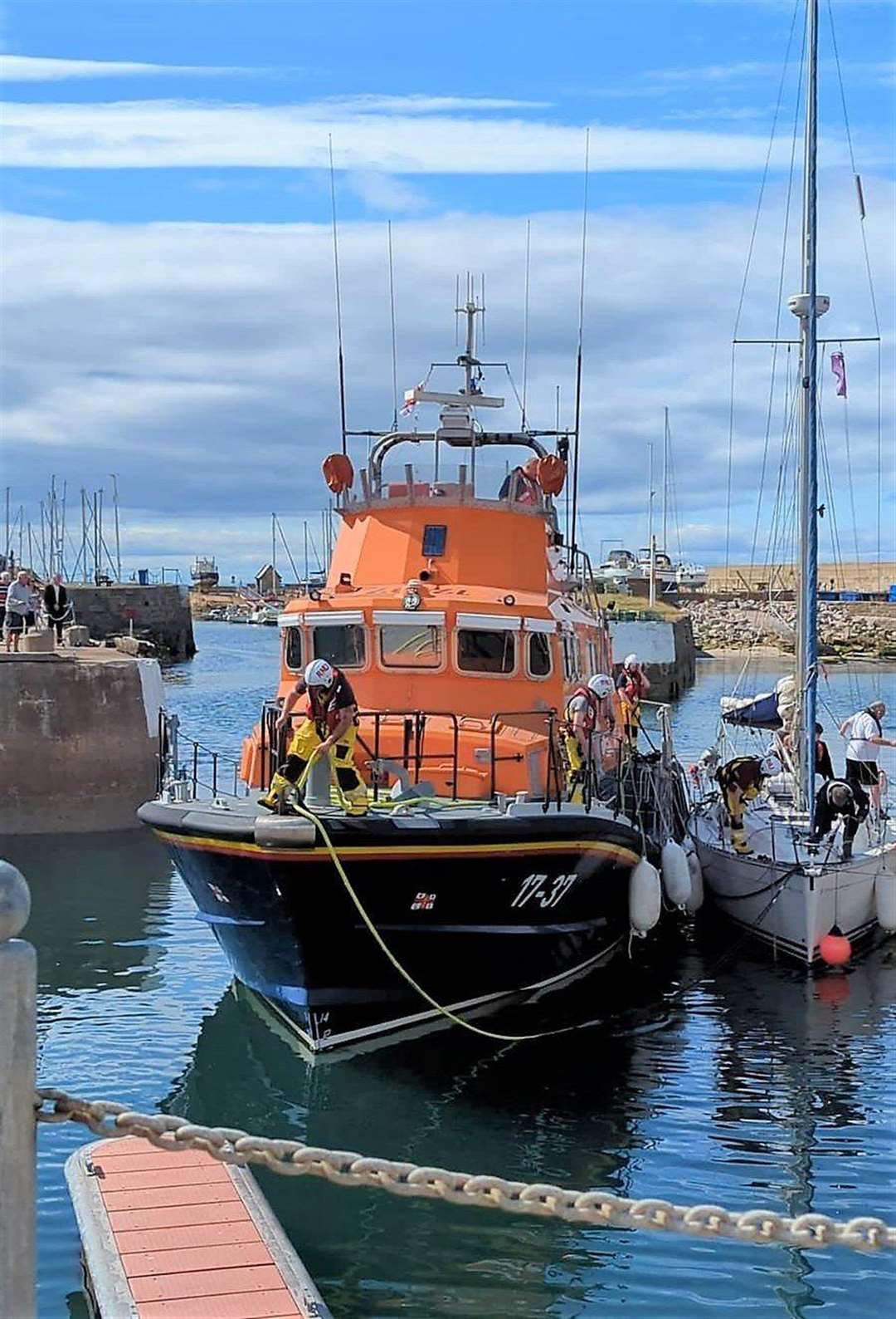 Almost home...the lifeboat brings the rescue vessels towards the pontoons at Lossiemouth Harbour. Picture Lynne Gray