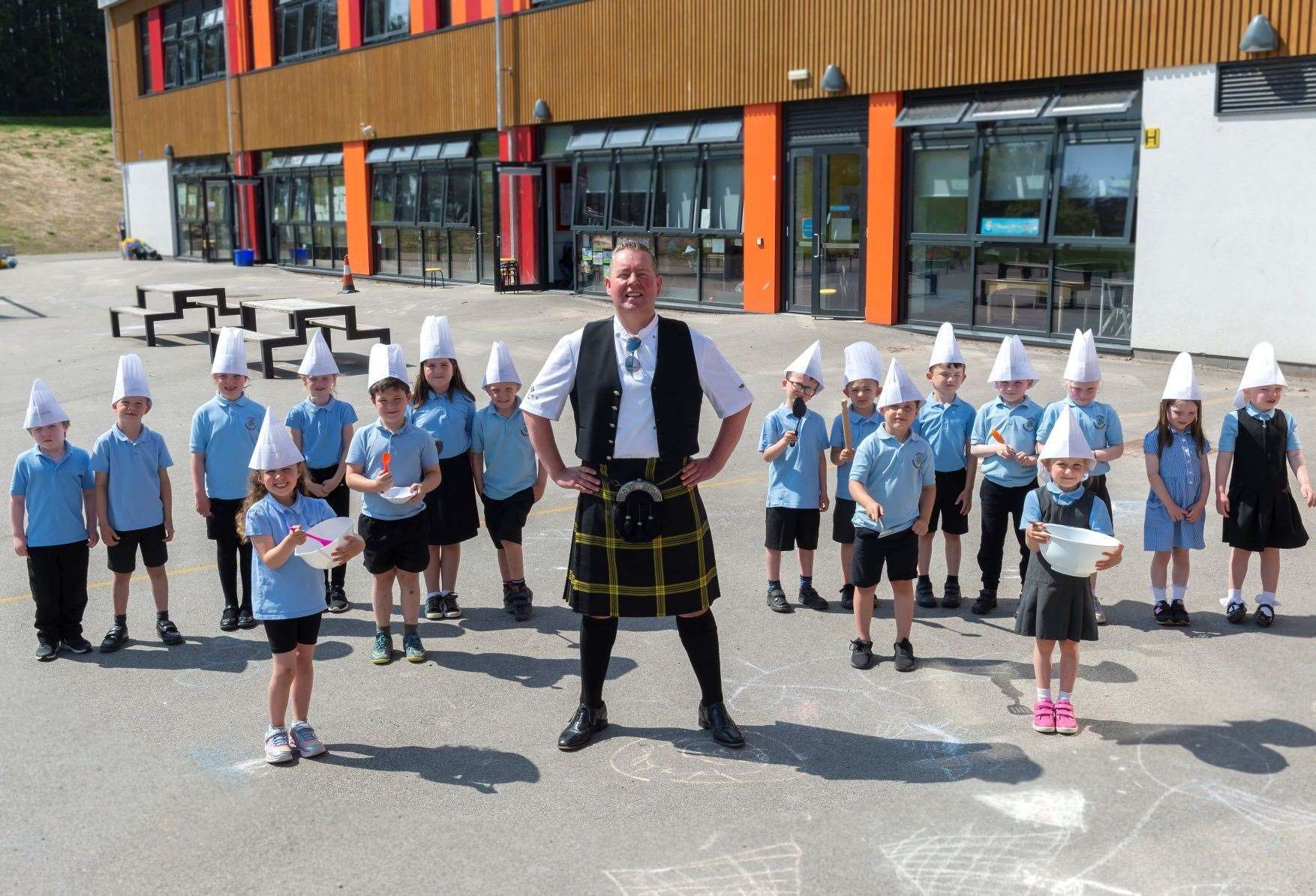 Craig Wilson, the Kilted Chef and owner of Eat on the Green restaurant launches the Kilted Kitchen Learning Project to inspire young people to share his passion for food, shown here with Primary 1 and Primary 2 pupils from Alford Primary School.