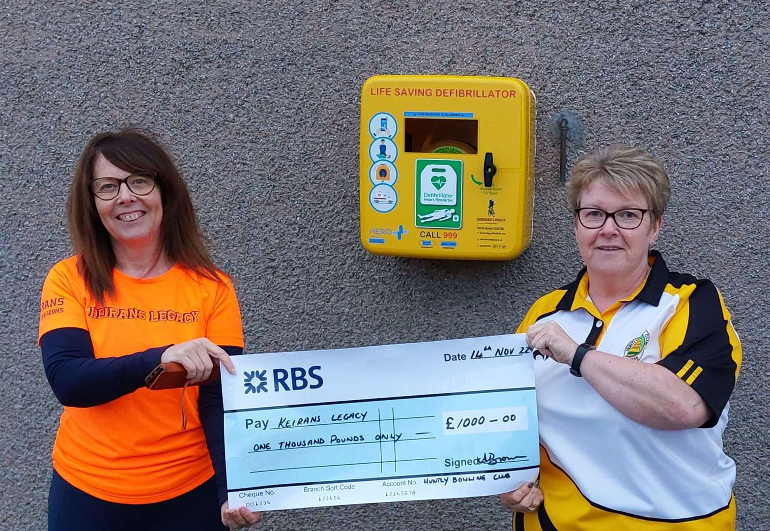 Sandra from Keiran's Legacy collecting the cheque from Audrey Brown, ladies secretary of Huntly Bowling Club.
