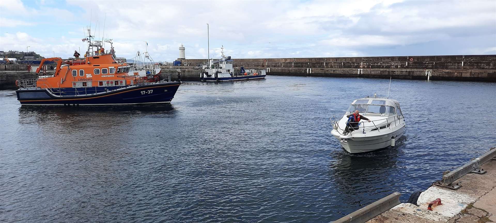 Buckie 's RNLI lifeboat William Blannin stands by as the motor cruiser manoeuvres to a berth at the harbour. Picture: Buckie RNLI