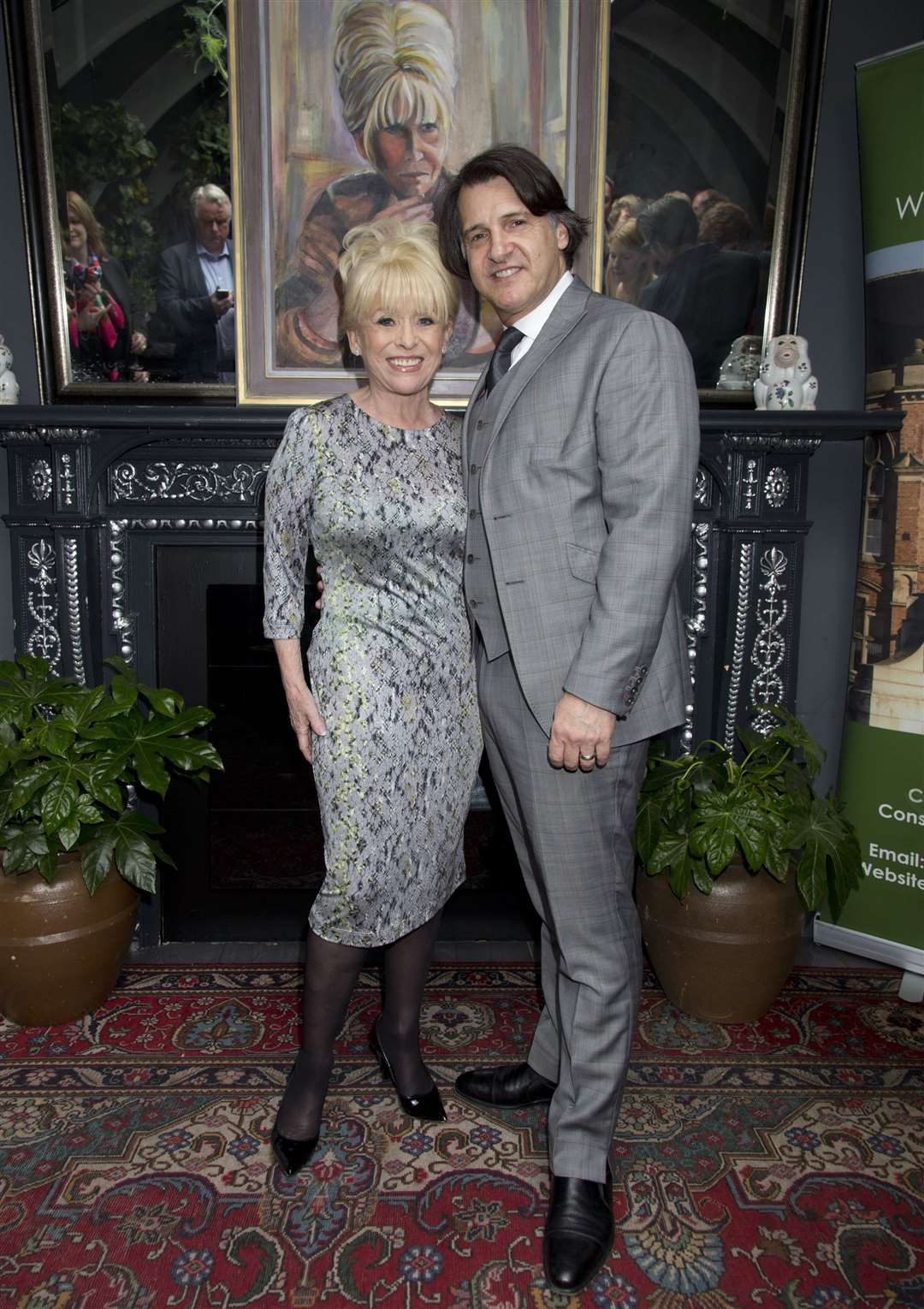 Barbara Windsor and Scott Mitchell with a portrait of the actress by Welsh artist Dan Llywelyn Hall, at L’Escargot in London (Yui Mok/PA)