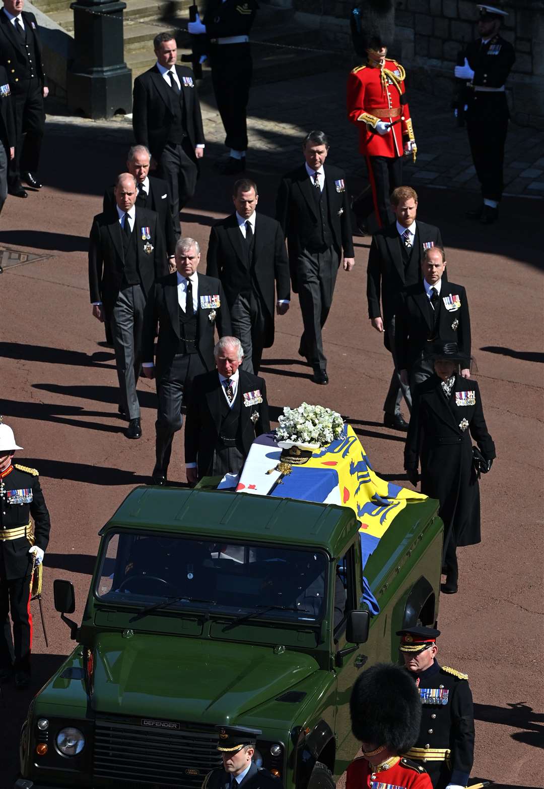 The Duke of Edinburgh’s coffin, covered with his personal standard, is carried on the purpose-built Land Rover Defender outside St George’s Chapel (Justin Tallis/PA)
