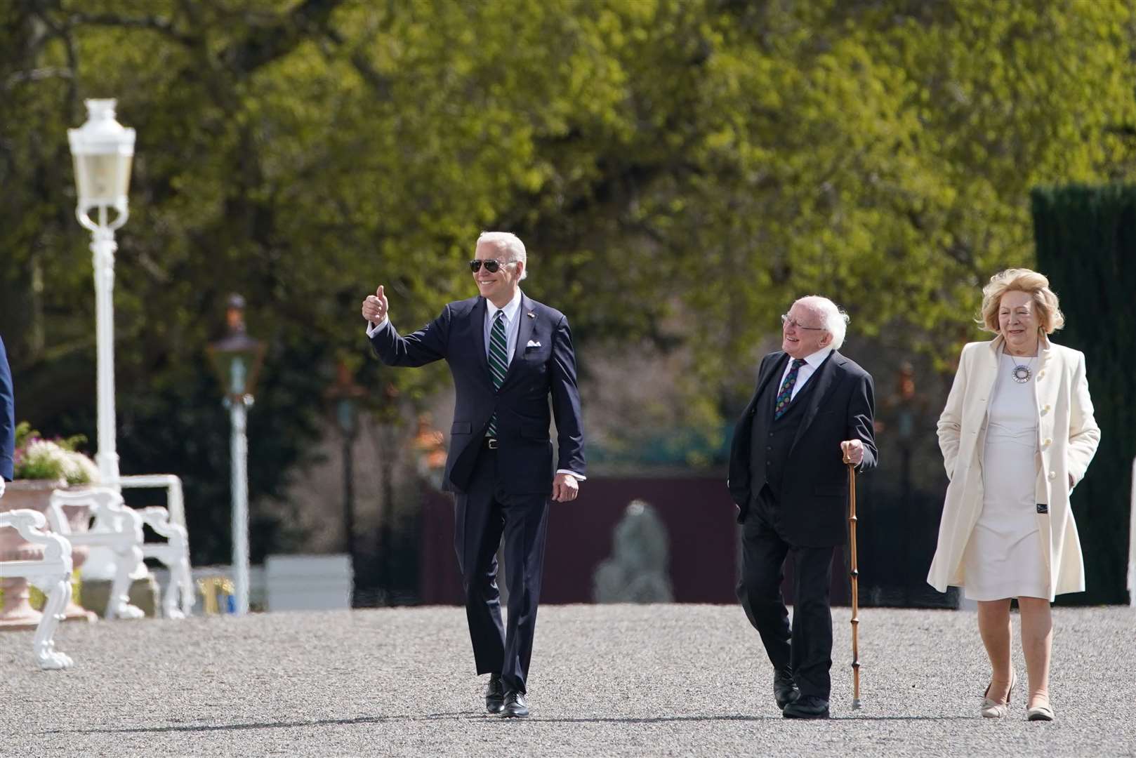 Joe Biden waves to onlookers as he takes a stroll in Phoenix Park with Michael D Higgins and his wife Sabina (Brian Lawless/PA)