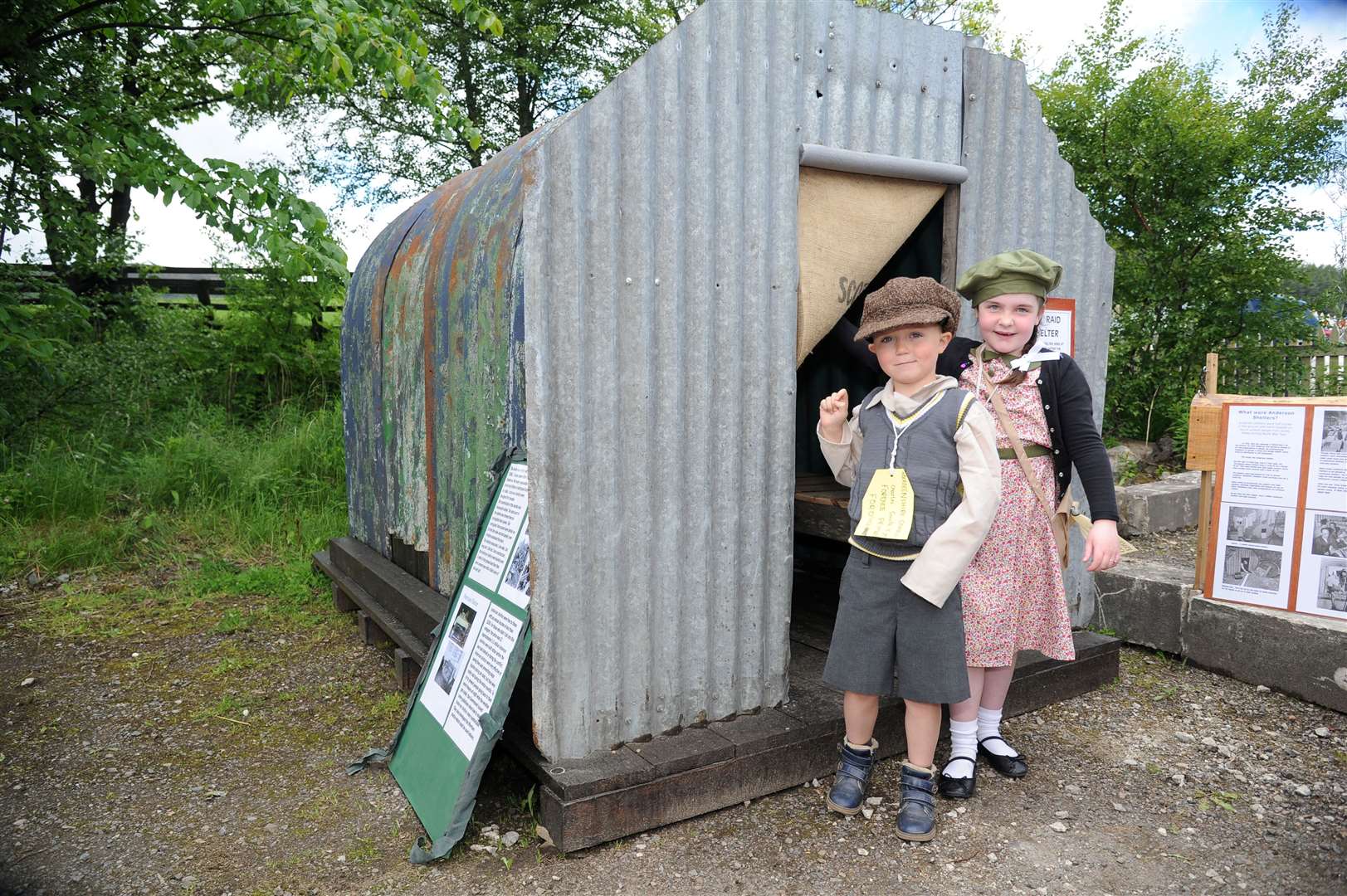 Charles Smith And Dakota Meldrum emerge from an Anderson Shelter. Families of more than four would have to share beds during air raids. Picture: Eric Cormack. Image No.044182.