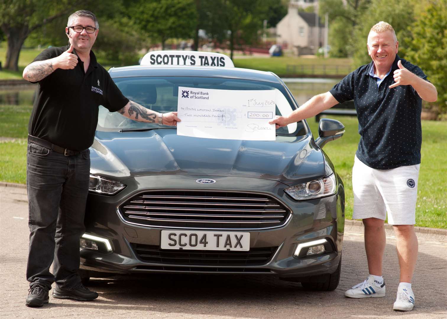 Taxi driver Scotty Russell hands over a cheque to Andy.