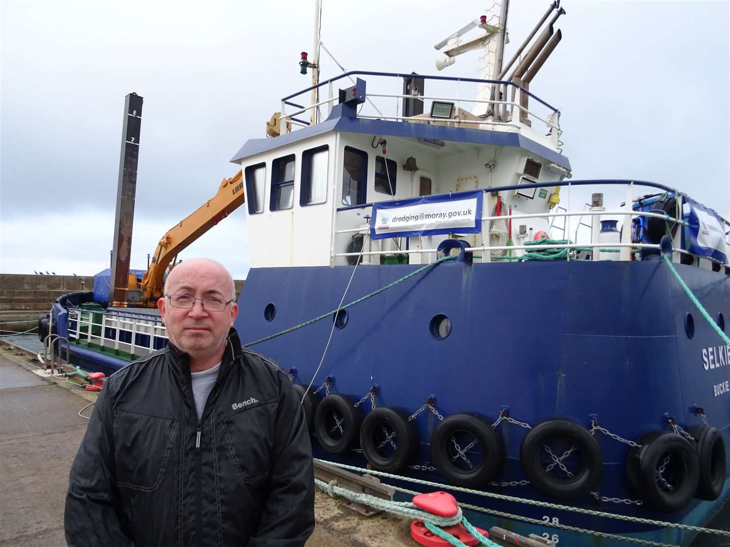 Councillor Marc Macrae stands alongside the controversy-dogged dredger MV Selkie.