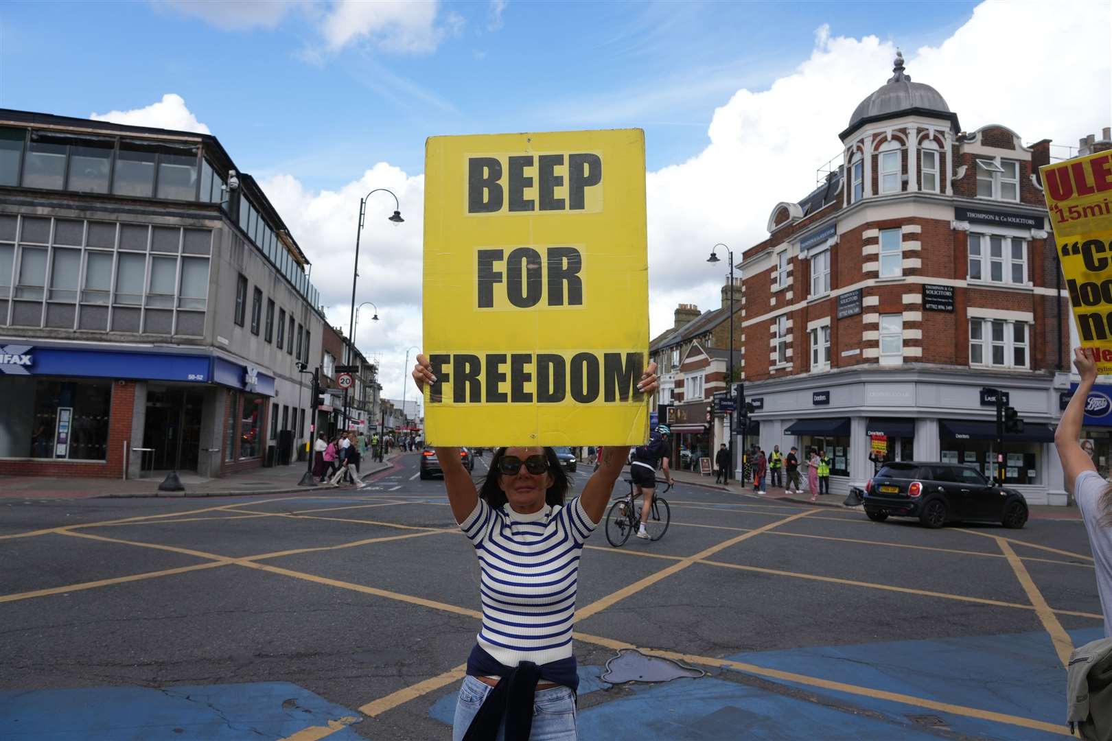 A protester urges motorists to signal their support (Jeff Moore/PA)