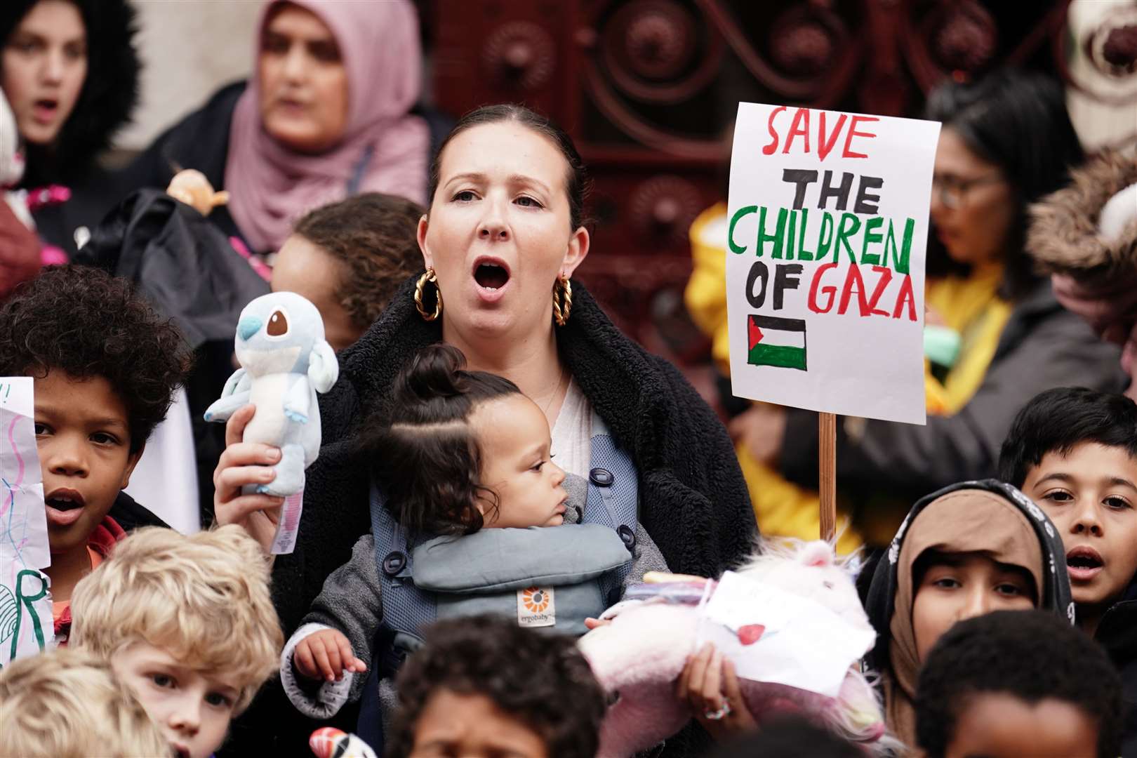 Parents and children lay out cuddly toys across the entrance to the Foreign Office in London as they protest to save children’s lives in Gaza (Jordan Pettitt/PA)
