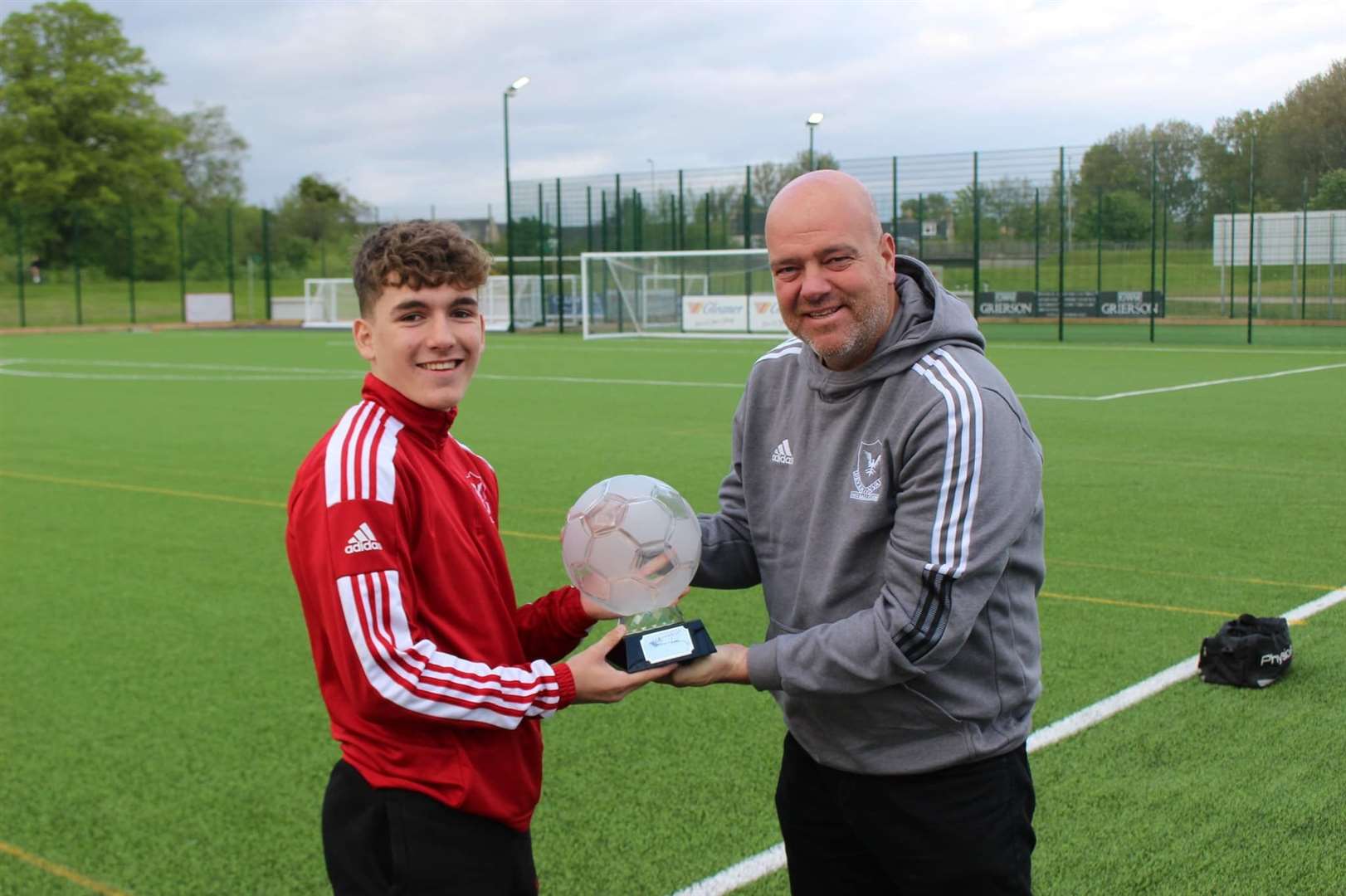 Jayden Goldie is presented with the Lee Henderson Trophy for most-improved under-19s player by Deveronvale first team manager Craig Stewart.