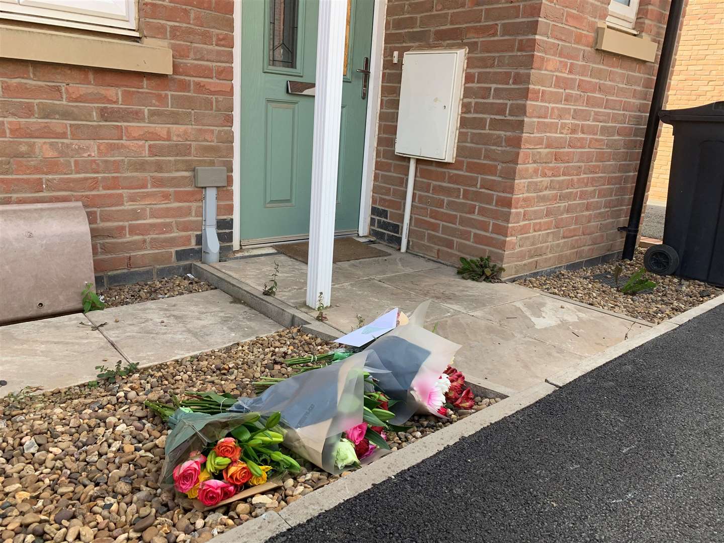 Floral tributes left near to the scene in Field Edge Drive (Josh Payne/PA)