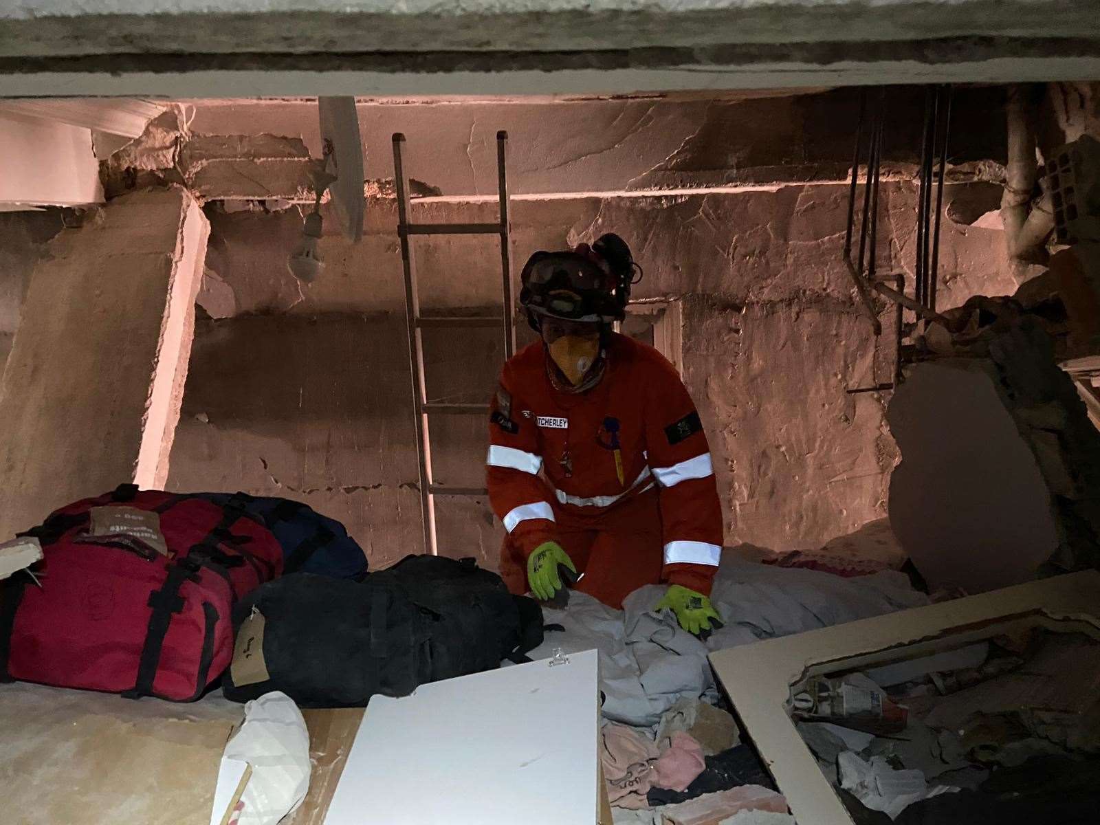 Emma Atcherley rescuing a man whose legs are trapped in the rubble of a collapsed building (FCDO/PA)