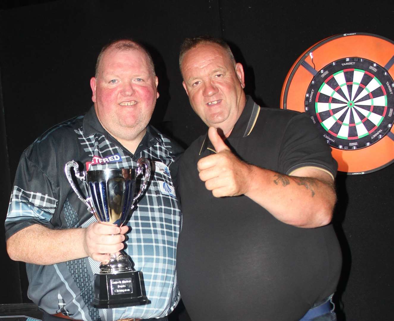 Darts professional John Henderson from Huntly receives the winner's trophy from main sponsor Tom Acutt. Picture: Graham Watson