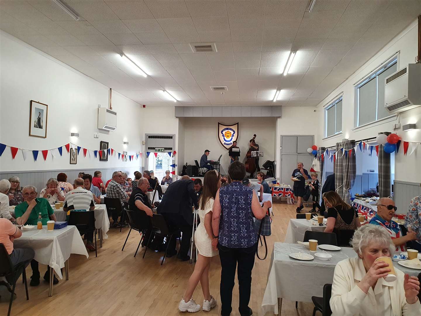 The main hall was packed with people enjoying refreshments and a live jazz band.