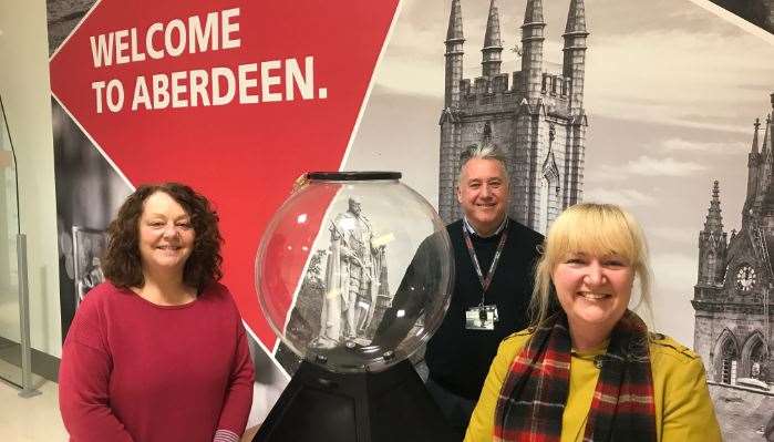 At one of the collection globes in Aberdeen International Airport are Fiona Heinonen from Kayleigh’s Wee Stars, Mark Beveridge operations director at Aberdeen International Airport and Phionna McInnes from We Too!