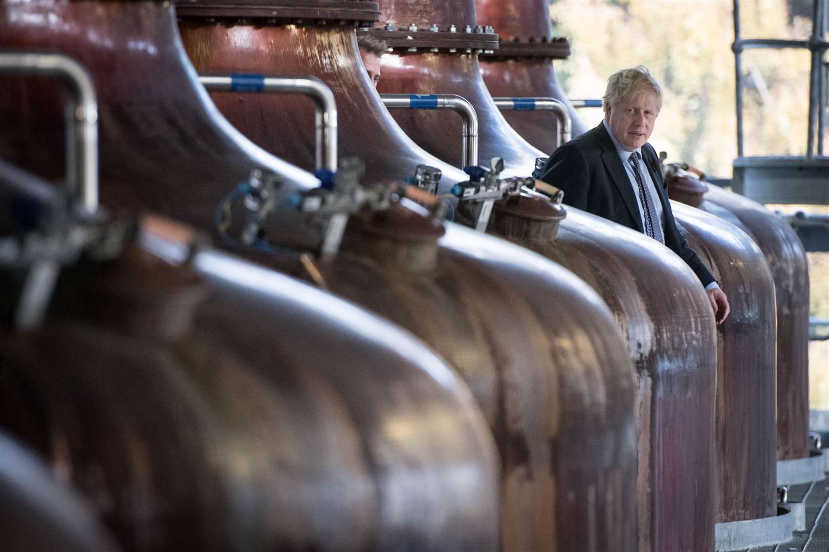 Prime Minister Boris Johnson amongst the whisky stills at the Roseisle Distillery in Scotland near Moray (Stefan Rousseau/PA)
