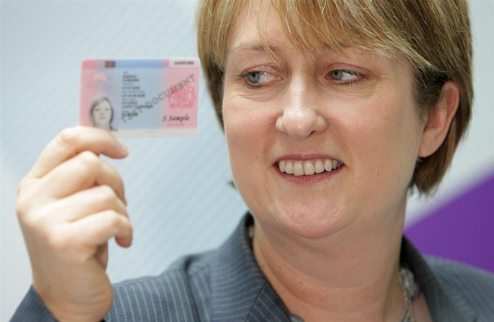 Jacqui Smith, the UK’s first female home secretary, pictured in 2008 holding an example of an identity card (Dominic Lipinski/PA)
