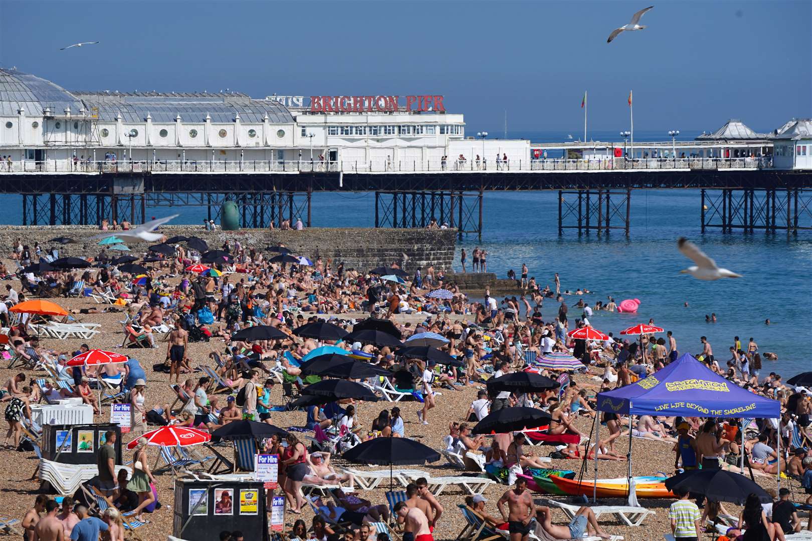 People enjoying the sunshine on Brighton beach (Aaron Chown/PA Images)