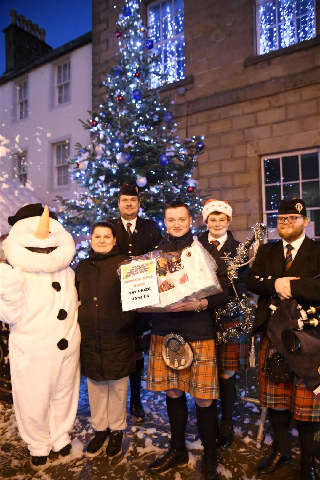 The bagpipers gifting the 1st place winner in the Ball Race a hamper at the Christmas Cracker. ..Banff Christmas Cracker, 2022...Picture: Beth Taylor.