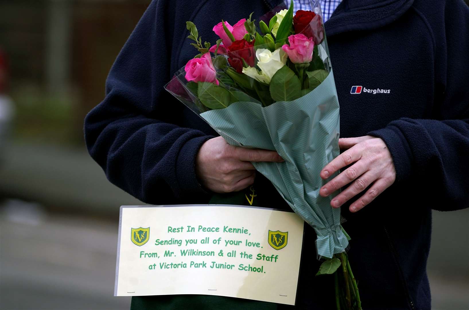 A member of public with flowers on Thirlmere Avenue in Stretford (Peter Byrne/PA)