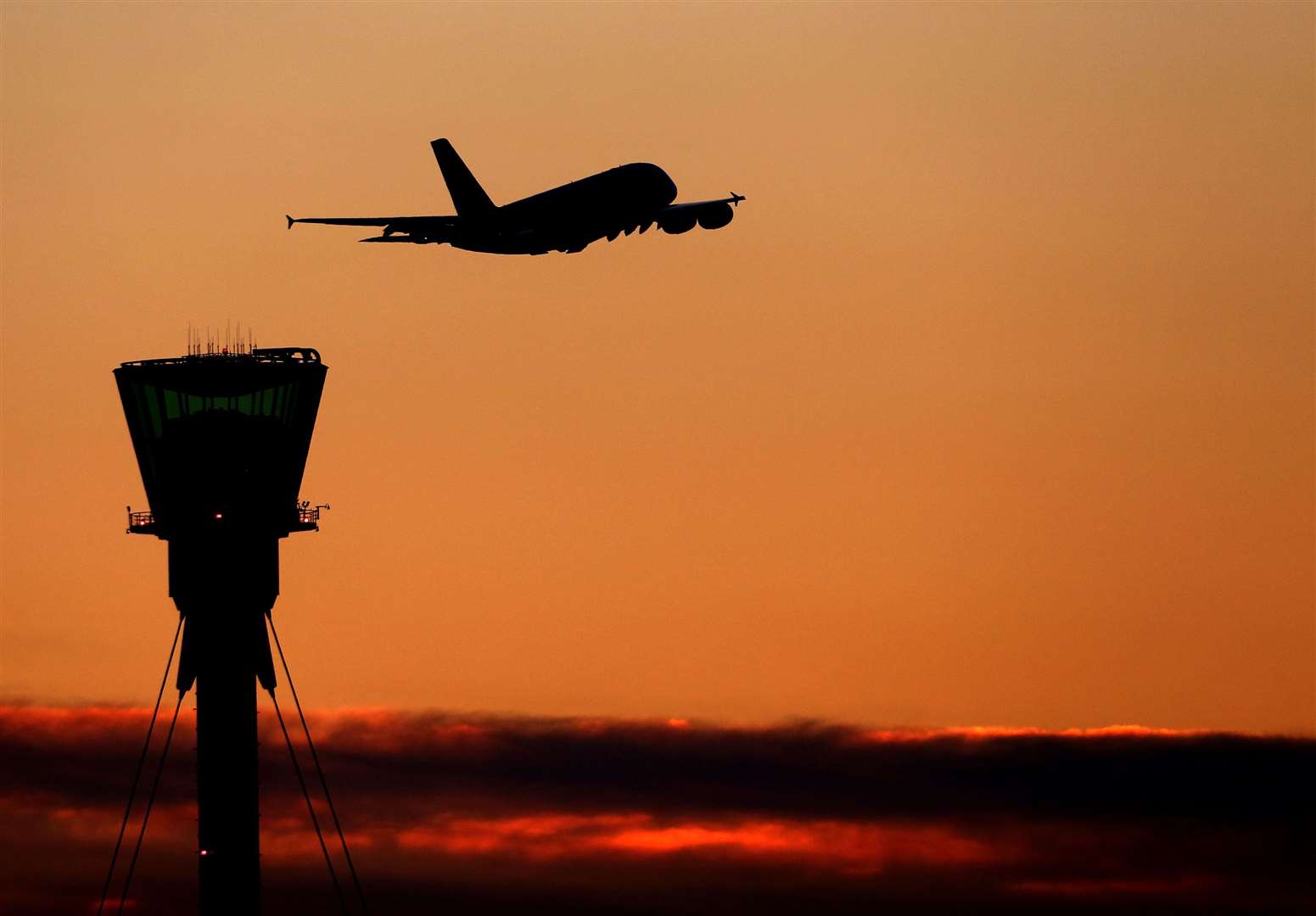 A plane at sunset over Heathrow Airport in London (Steve Parsons/PA)