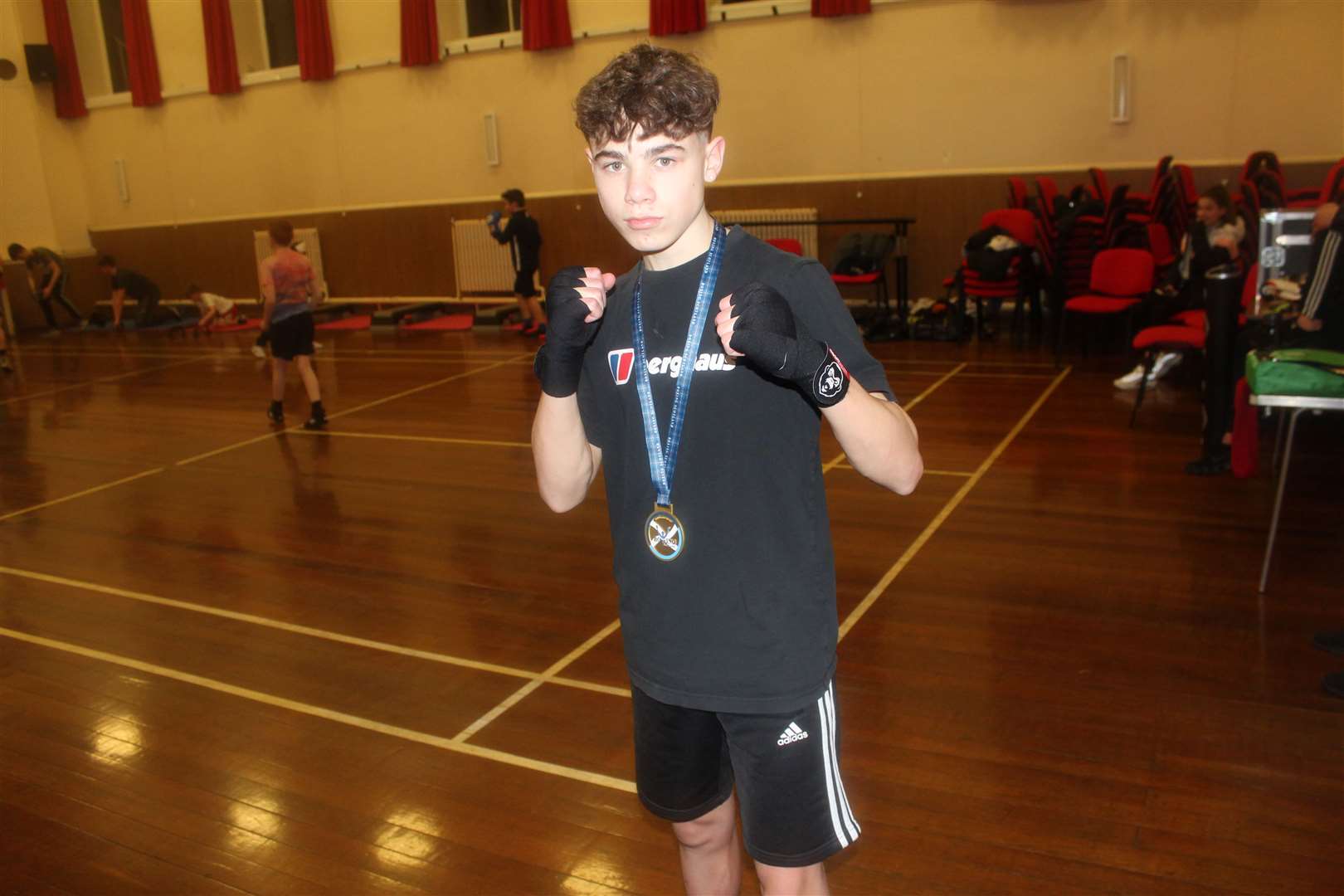 Boxer Nathaniel Cook proudly wearing his gold medal from the Intermediate Championships.