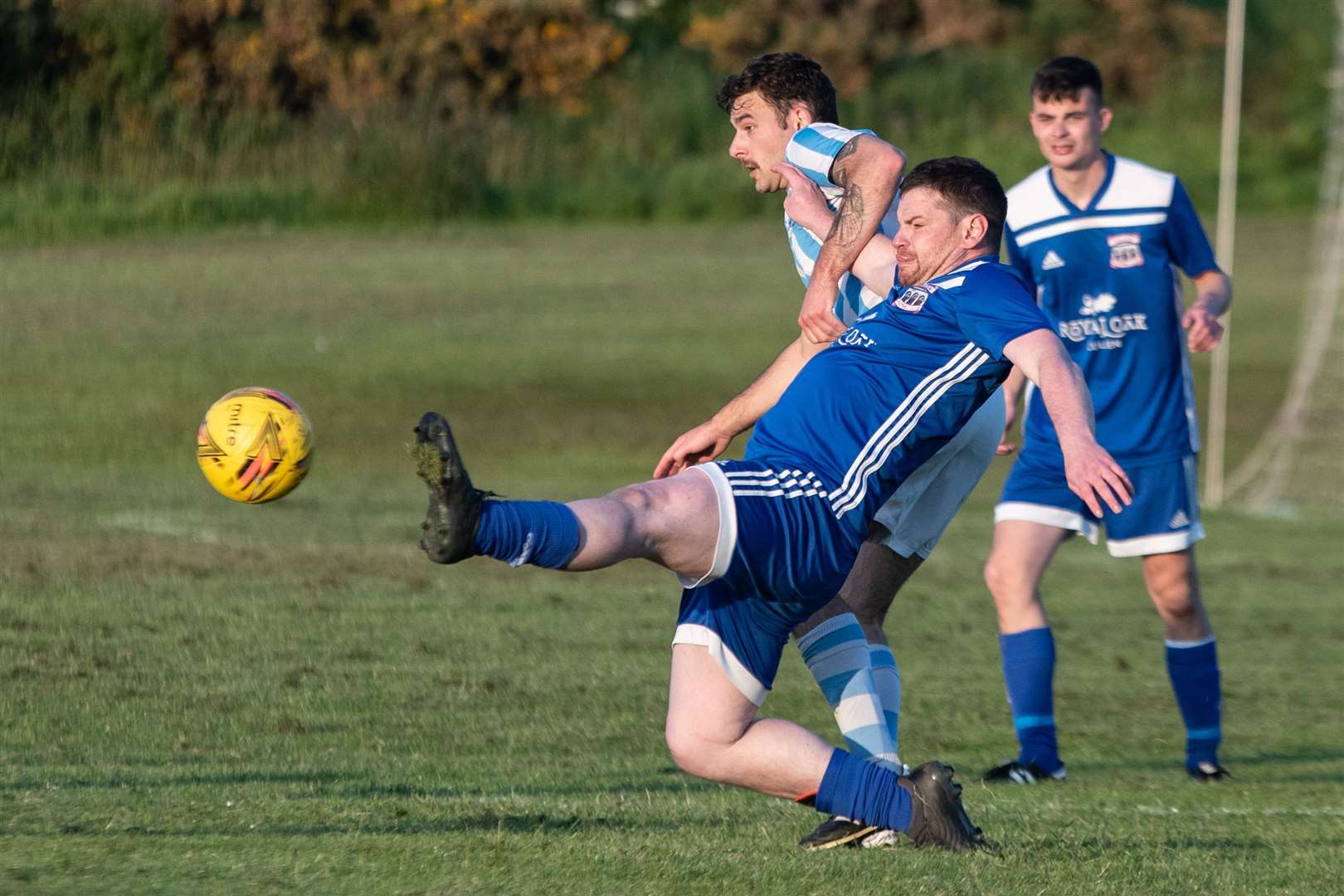 Cullen's Scott Mair is at full stretch to win the ball away from RAF Lossiemouth's Reece Archer. Picture: Daniel Forsyth